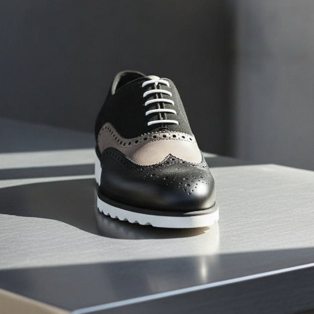 Black and white MERRIMIUM brogue shoe on a reflective surface with a dark background